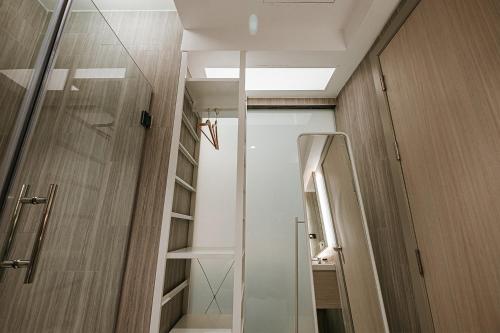 a bathroom with a shower and a glass door at The Rich Hotel in Nakhon Ratchasima