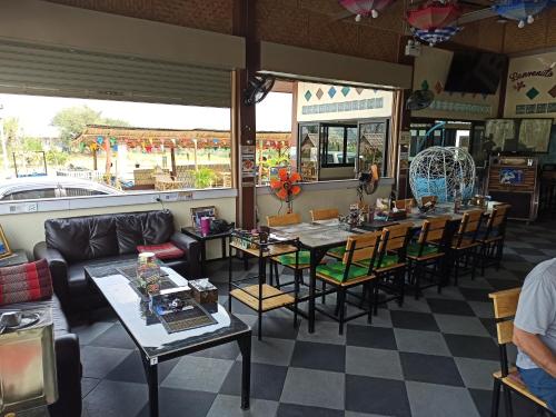a restaurant with tables and chairs in a room at Touch the Wind in Chaiyaphum