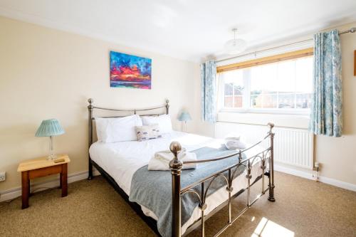 ein Schlafzimmer mit einem Bett und einem Fenster in der Unterkunft Poplars in Aldeburgh