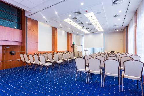 a row of chairs in a room with blue carpet at Qubus Hotel Gorzów Wielkopolski in Gorzów Wielkopolski
