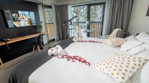 a bedroom with a large white bed with flowers on it at Lyra Hotel Plitvice in Ličko Petrovo Selo