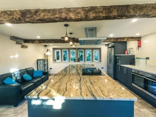 a kitchen and living room with a large wooden counter top at Luxury traditional stone farmhouse in Saddleworth in Oldham