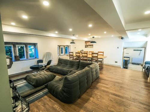a living room with a large couch and a table at Luxury traditional stone farmhouse in Saddleworth in Oldham
