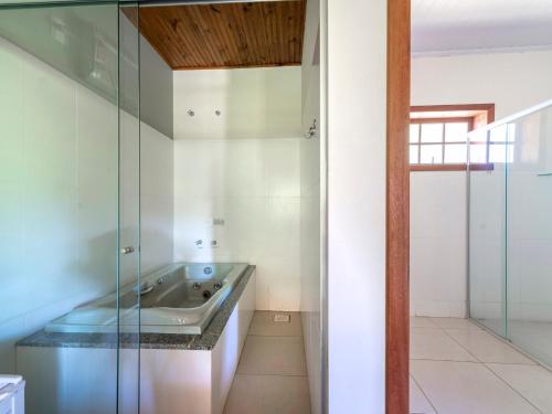 a bathroom with a tub and a glass shower at Hotel Fazenda Morada Do Imperador in Barbacena