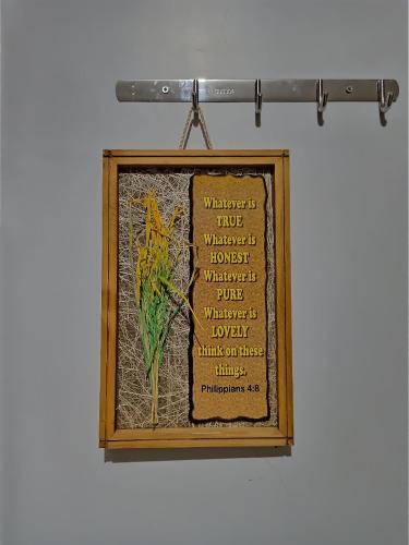 a framed picture of a plant on a wall at D' Partner's Inn in Jagna