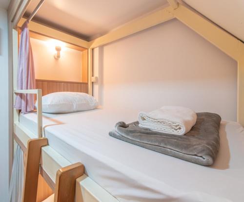 a bed with a blanket on it in a room at The Victory View in Bangkok