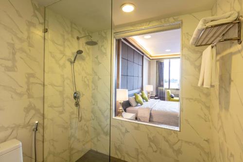 a bathroom with a shower and a mirror at Savan Resorts in Savannakhet