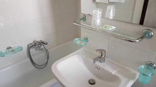 La salle de bains blanche est pourvue d'un lavabo et d'une baignoire. dans l'établissement Grande Albergo Abruzzo, à Chieti