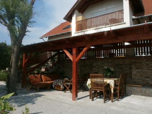 a patio with a wooden pergola with a table and chairs at Fehér Rózsa Apartman in Cserszegtomaj