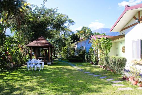 a garden with a table and a gazebo at Dream Home B&B in Hualien City