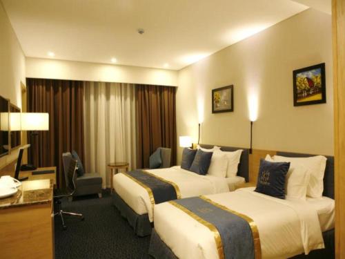 Ciao SaiGon Hotel & Spa في مدينة هوشي منه: غرفة فندقية بسريرين ومكتب