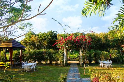 a garden with white chairs and a gazebo at Dream Home B&B in Hualien City