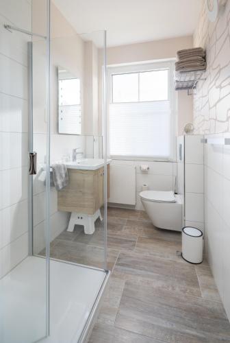 a bathroom with a tub and a sink and a toilet at Winkelschiffchen II mit Sauna in Juist