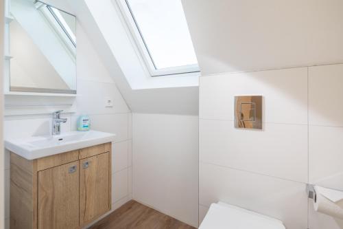 a bathroom with a sink and a skylight at Winkelschiffchen II mit Sauna in Juist