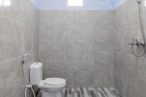 a bathroom with a toilet and a shower at RedDoorz Syariah @ Bondowoso City Center in Bondowoso