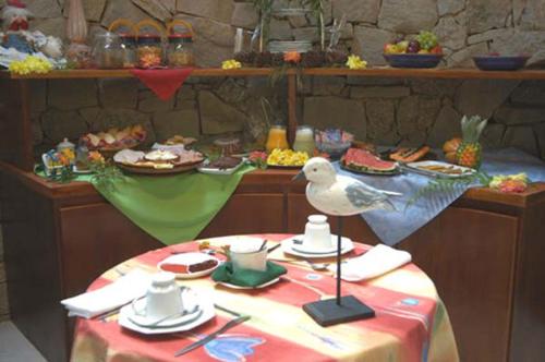 a table with a bird sitting on top of it at Bromélia Sabiá & Cia in Teresópolis