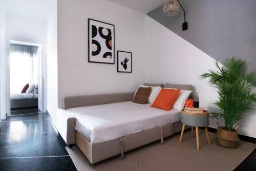 a bed with orange pillows in a living room at Sapore di Sori New Apartment in Sori