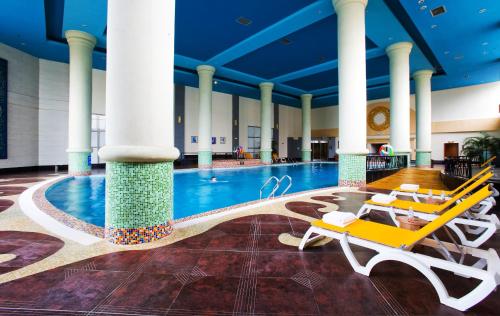 Chengdu Wangjiang Hotel في تشنغدو: مسبح في فندق مع كراسي ومسبح