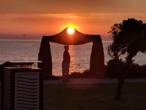 a person standing under an arch with the sunset in the background at Bunbury's Most Convenient Location in Bunbury