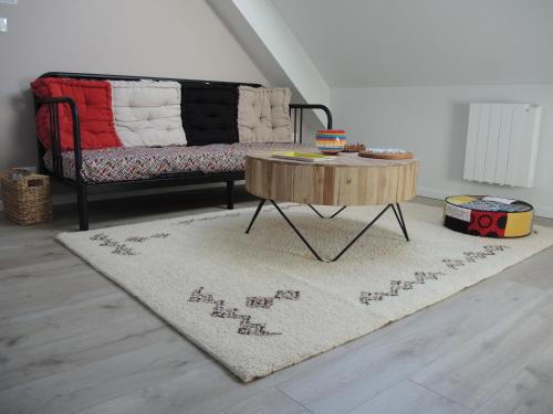a living room with a couch and a coffee table at Chambres d'Hôtes les Colombes in Montmort-Lucy