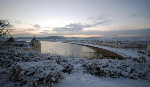 a bridge over a river with snow on the ground at Imperial Hotel in Llandudno