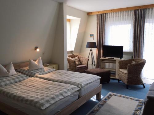 una camera d'albergo con due letti e una televisione di Horn's Gästehaus a Bad Steben