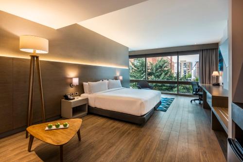 una camera d'albergo con un letto e una grande finestra di Holiday Inn Express Bogotá - Parque La 93, an IHG Hotel a Bogotá