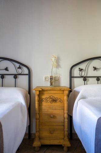 a bedroom with two beds and a wooden table between two beds at Hostal Valle Del Sol Alora in Alora