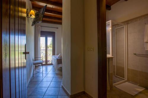 einen Flur mit Bad mit Dusche und Tür in der Unterkunft Hostal Valle Del Sol Alora in Alora
