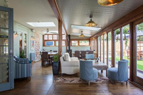 a living room with tables and chairs and windows at The Lodge in Hunstanton
