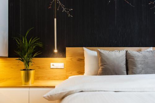 a bedroom with a white bed and a plant at Bed&Bath Luxury Apartments in Kraków