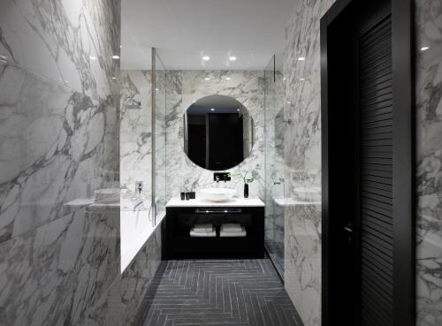 a bathroom with a sink and a mirror at Pelagos Suites Hotel & Spa in Kos Town