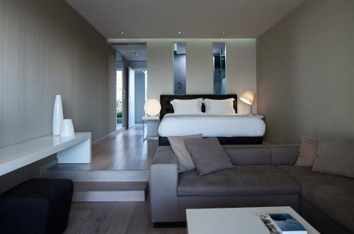 a large bedroom with a bed and a couch at Pelagos Suites Hotel & Spa in Kos Town
