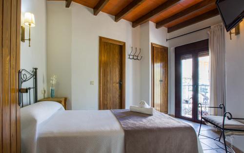 a bedroom with a white bed and a window at Hostal Valle Del Sol Alora in Alora