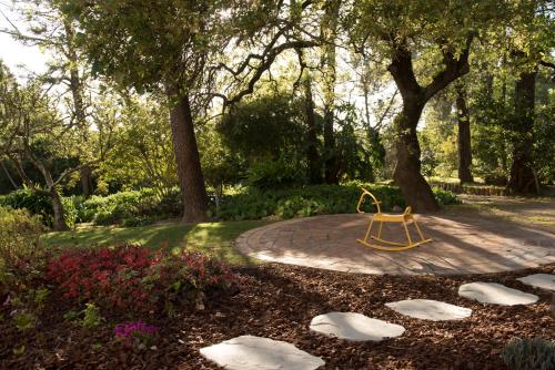 a yellow bench in a park with trees and flowers at Quinta das Pedras in Sintra