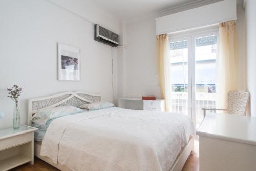 una camera bianca con un letto e una finestra di Flat in central Athens - Pangrati ad Atene
