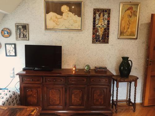 a living room with a television on a wooden cabinet at Willa Danusia in Milanówek
