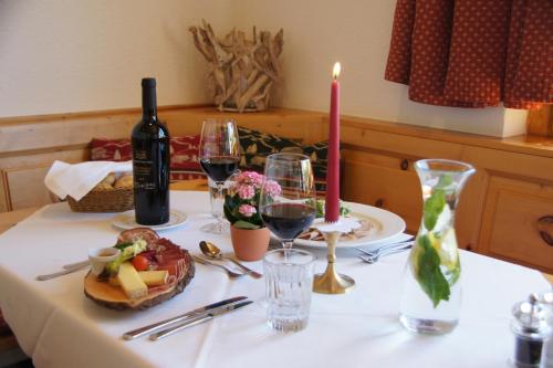 a table with wine glasses and a bottle of wine at Sternwarte by Randolins in St. Moritz