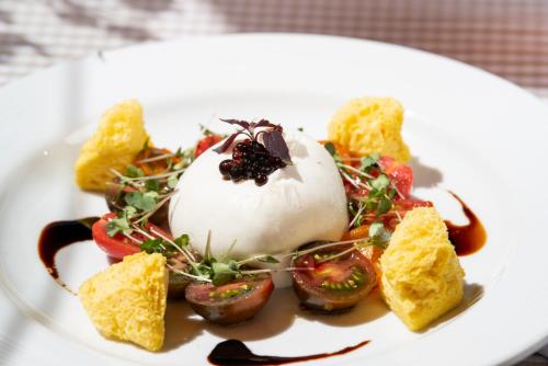 a white plate with a dessert with vegetables and sauce at Sternwarte by Randolins in St. Moritz