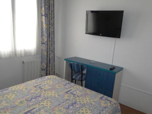 1 dormitorio con 1 cama y TV en la pared en Hotel La Torre, en Calella de Palafrugell