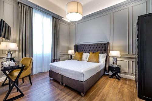 1 dormitorio con cama, escritorio y silla en Hotel Ungherese Small Luxury Hotel, en Florencia