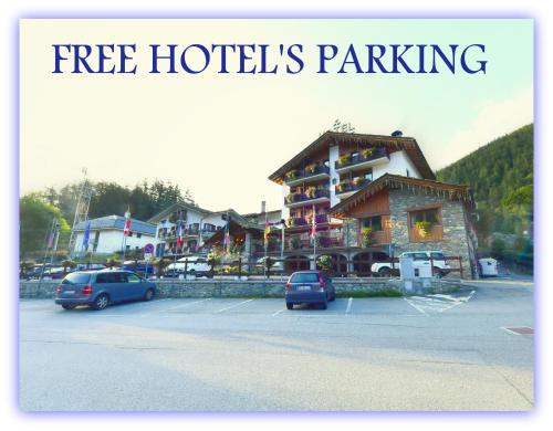 a parking lot with cars parked in front of a hotel at Hotel Beau Sejour in Etroubles