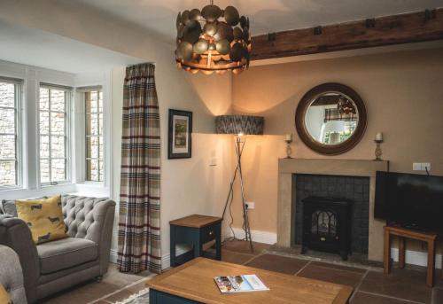 a living room with a couch and a fireplace at The Saddle Room in Middleham
