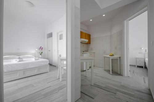 a white bedroom with a bed and a desk at Soula Naxos in Naxos Chora