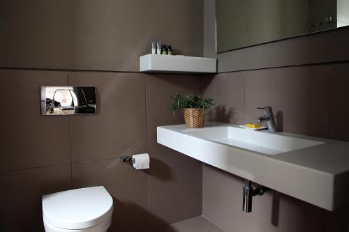 a bathroom with a white sink and a toilet at Skyros Ammos Hotel in Skiros