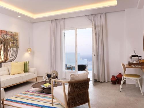a living room with a couch and a table at Myconian Korali Relais & Chateaux in Mýkonos City