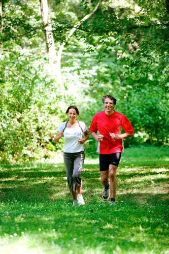 a man and a woman running in a park at Parkhotel zur Klause in Bad Hall