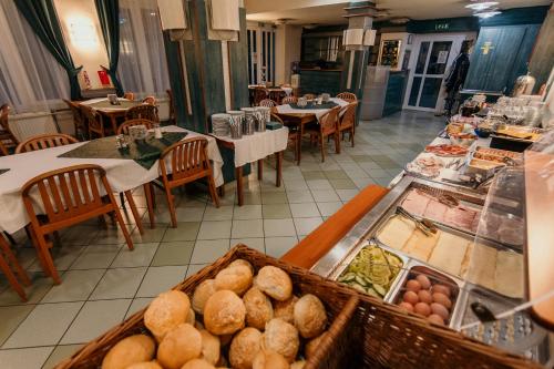 um restaurante com um buffet de comida e mesas em Tisza Sport Hotel em Szeged