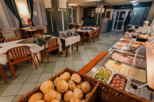 a restaurant with a buffet of food and tables at Tisza Sport Hotel in Szeged