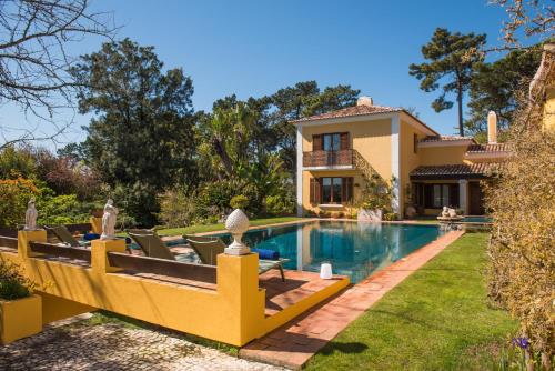 a villa with a swimming pool and a house at Quinta das Pedras in Sintra